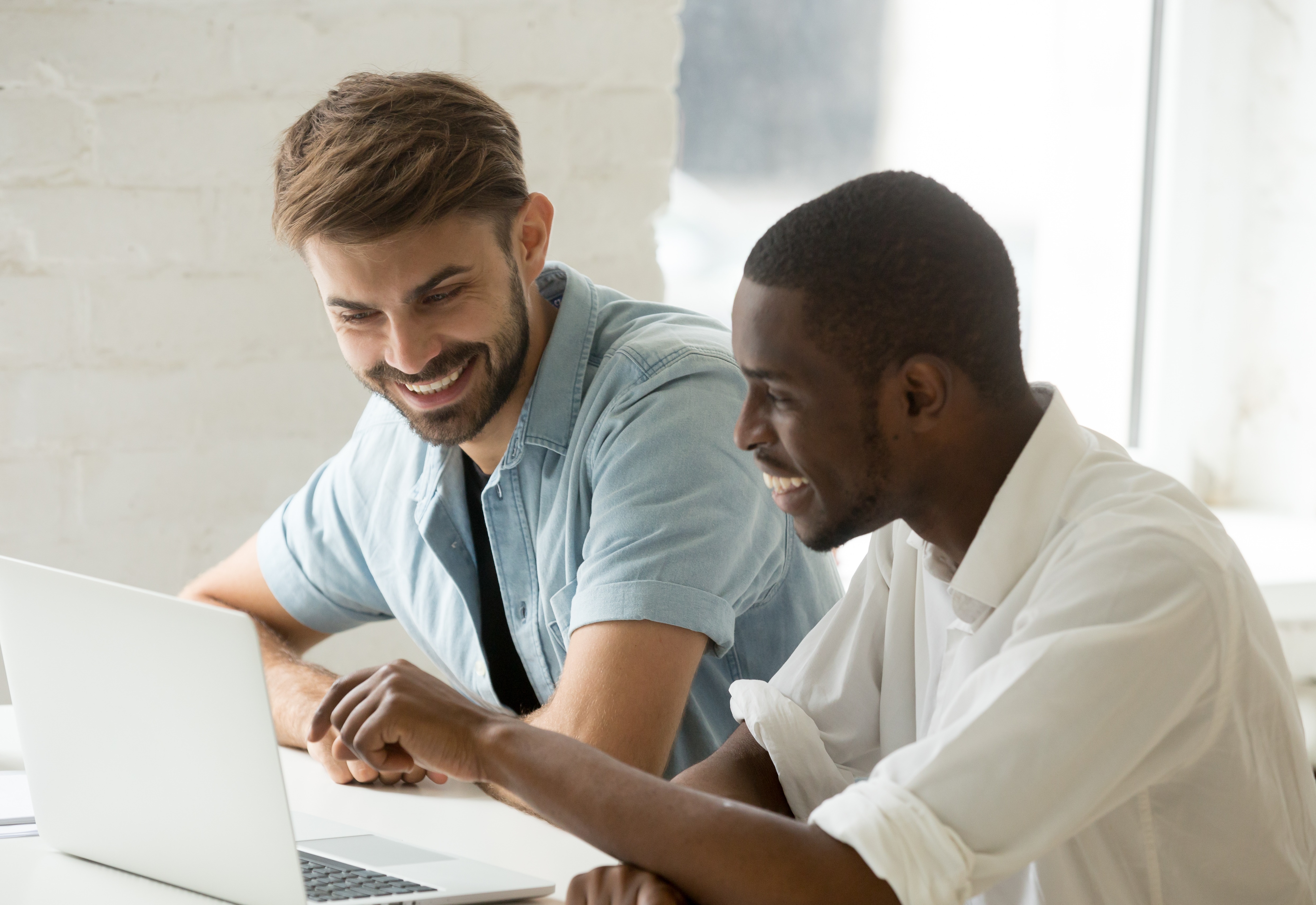 Two men looking at a laptop